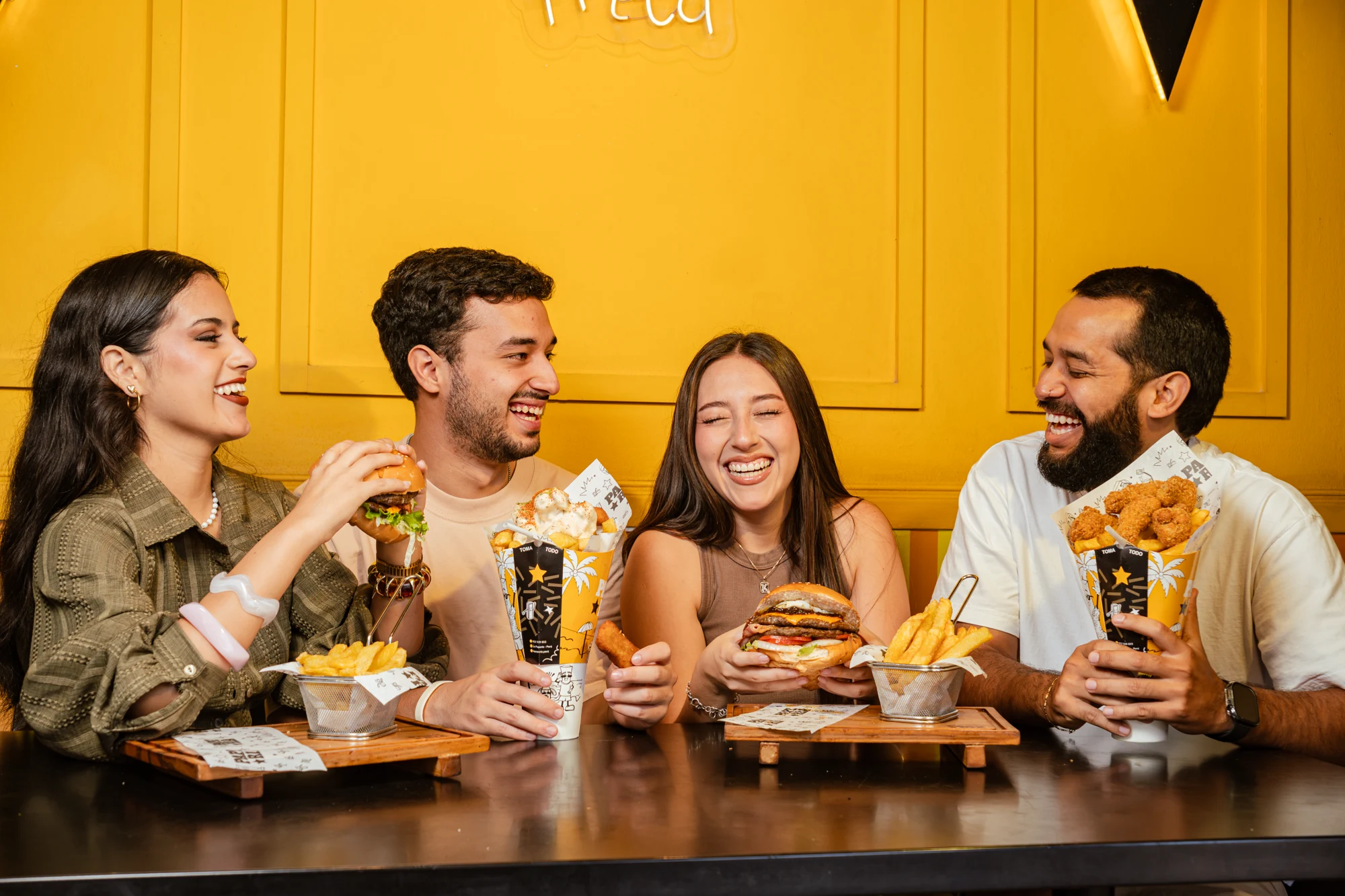 Producción fotográfica gastronómica con cuatro personas compartiendo alimentos